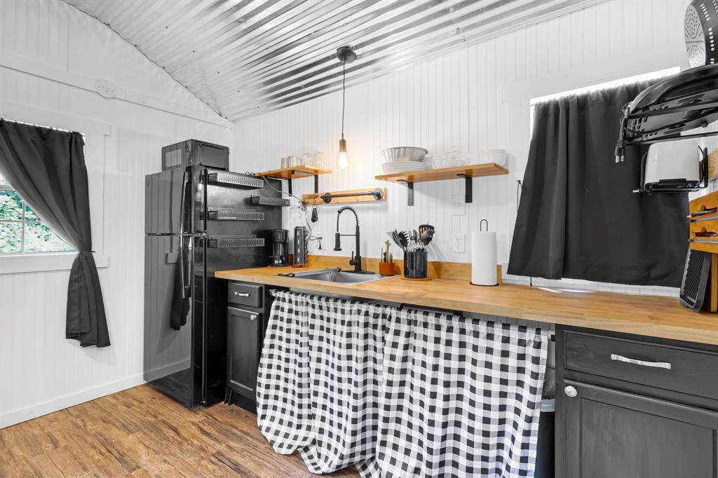 Functional kitchen area with modern plumbing, refrigerator, microwave, dishes, utensils and carefully selected finishes.