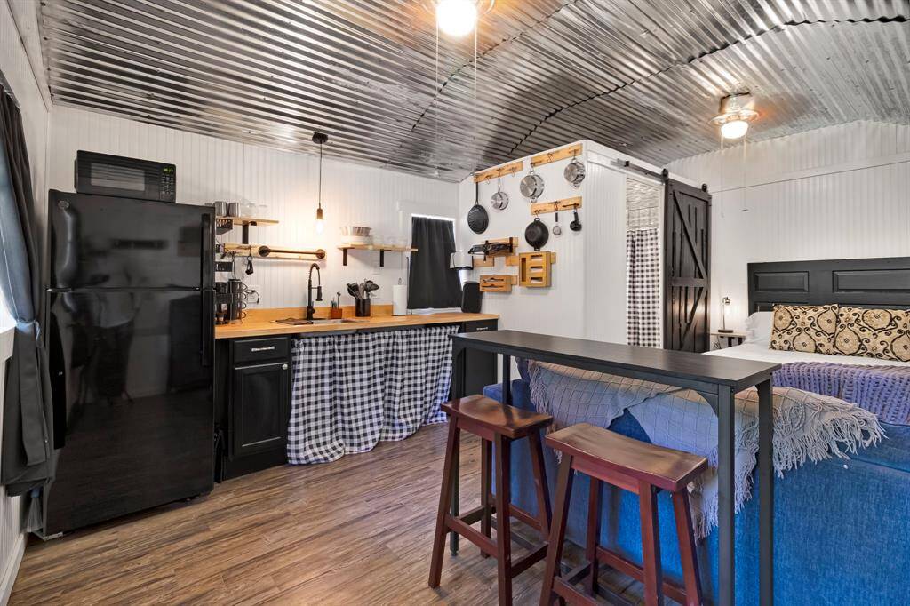 Functional kitchen area with modern plumbing, refrigerator, microwave, dishes, utensils and carefully selected finishes.
