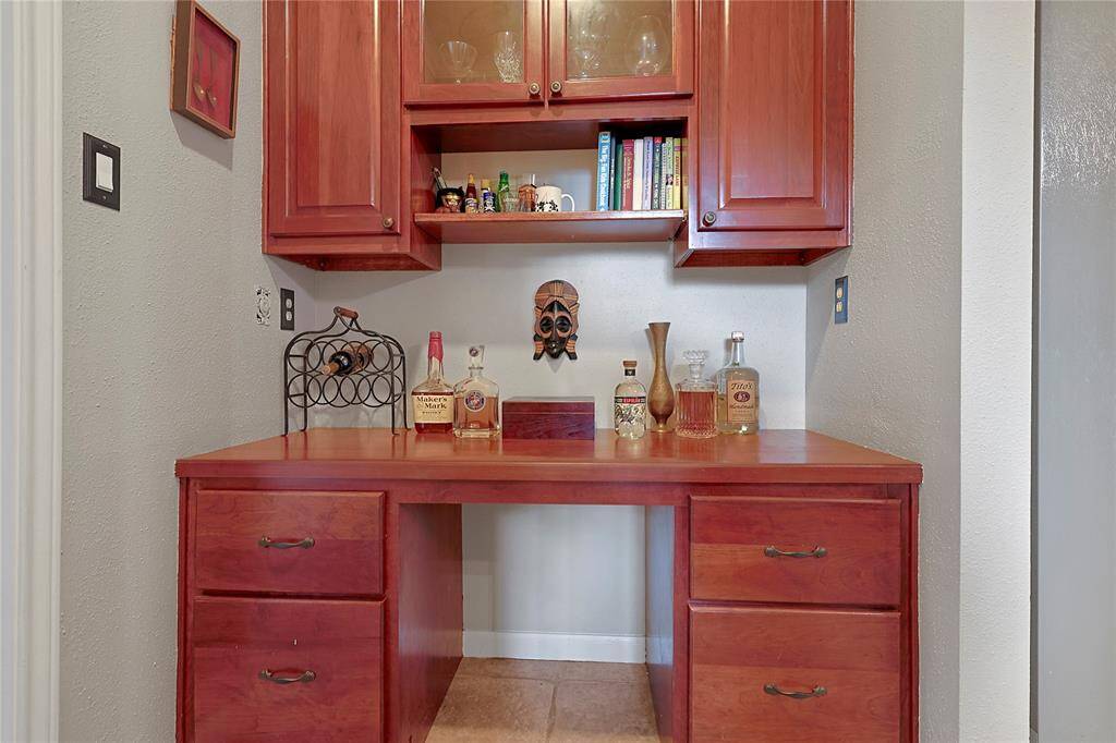 The dry bar has tile floors, woodcabinets, and plenty of storagespace.