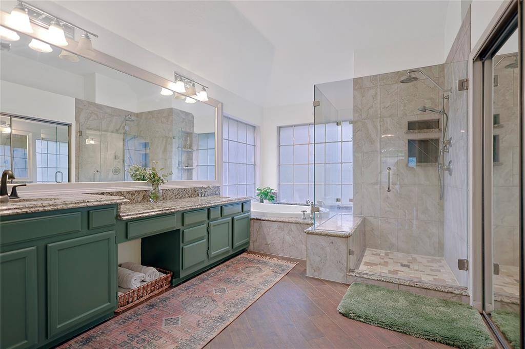 The primary bathroom features dualsinks, vanity area, walk-in showerwith sitting area, and separategarden tub.