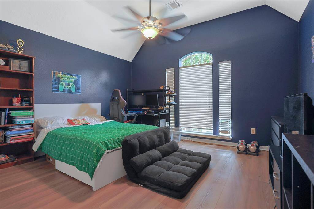 Secondary bedroom features largewindows, custom paint, and a ceilingfan.