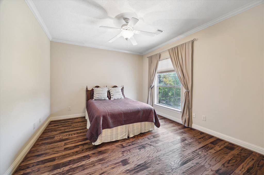 This secondary bedroom upstairs features beautiful wood floors and a spacious walk-in closet.