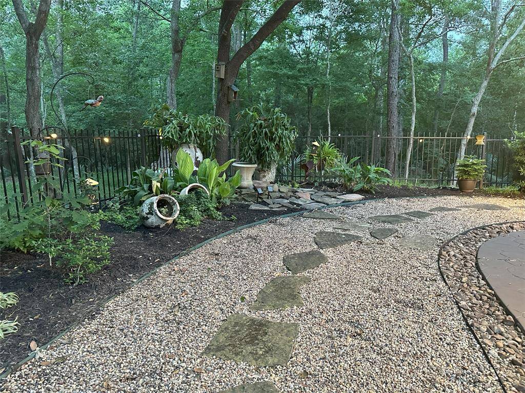 The backyard is beautifully enhanced with lush landscaping and a charming fountain.