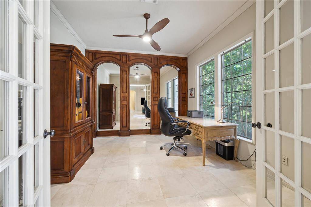 The dedicated home office features double doors for privacy and a mirrored accent wall that enhances the sense of space.