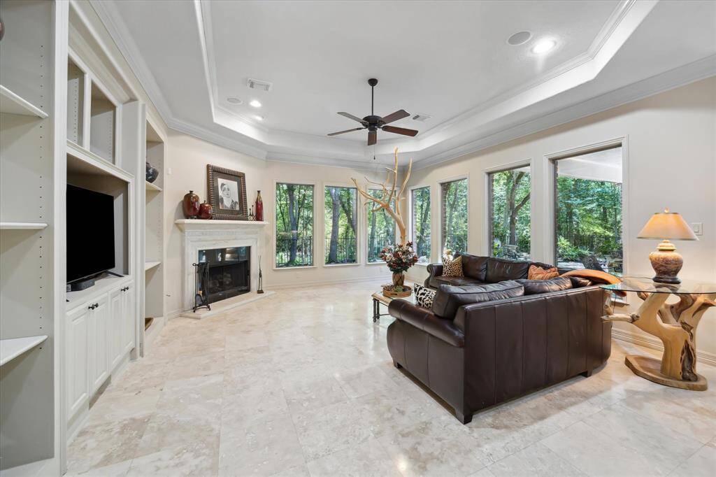 The spacious living room showcases an elegant fireplace and floor-to-ceiling windows that fill the space with natural light.