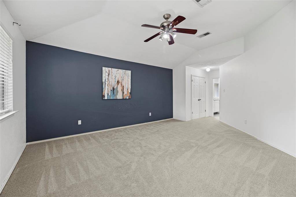 Spacious Primary bedroom with ceiling fan, natural light, two closets and an updated en suite bath.