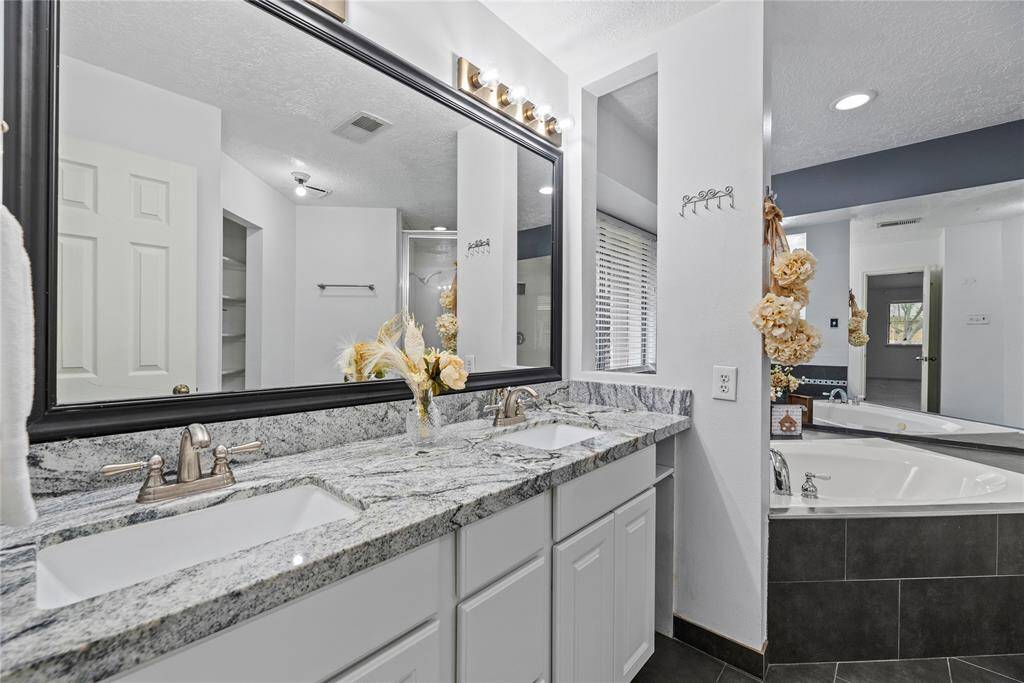Primary bathroom features a double sink vanity with updated fixtures and granite countertops. A lot of storage space as well!