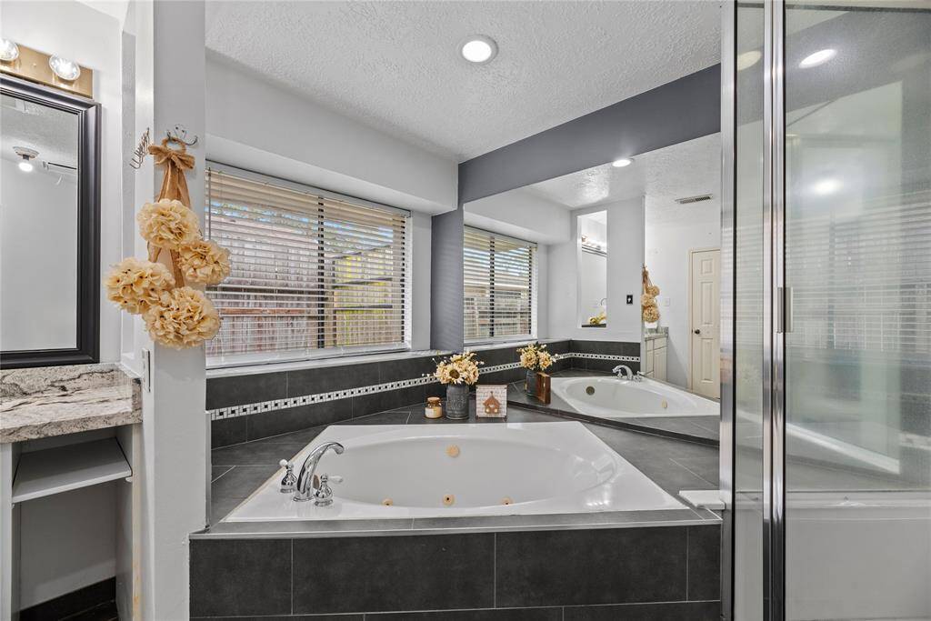 A nicely appointed corner bathtub with a nice ledge for all of your bath accessories and decor.