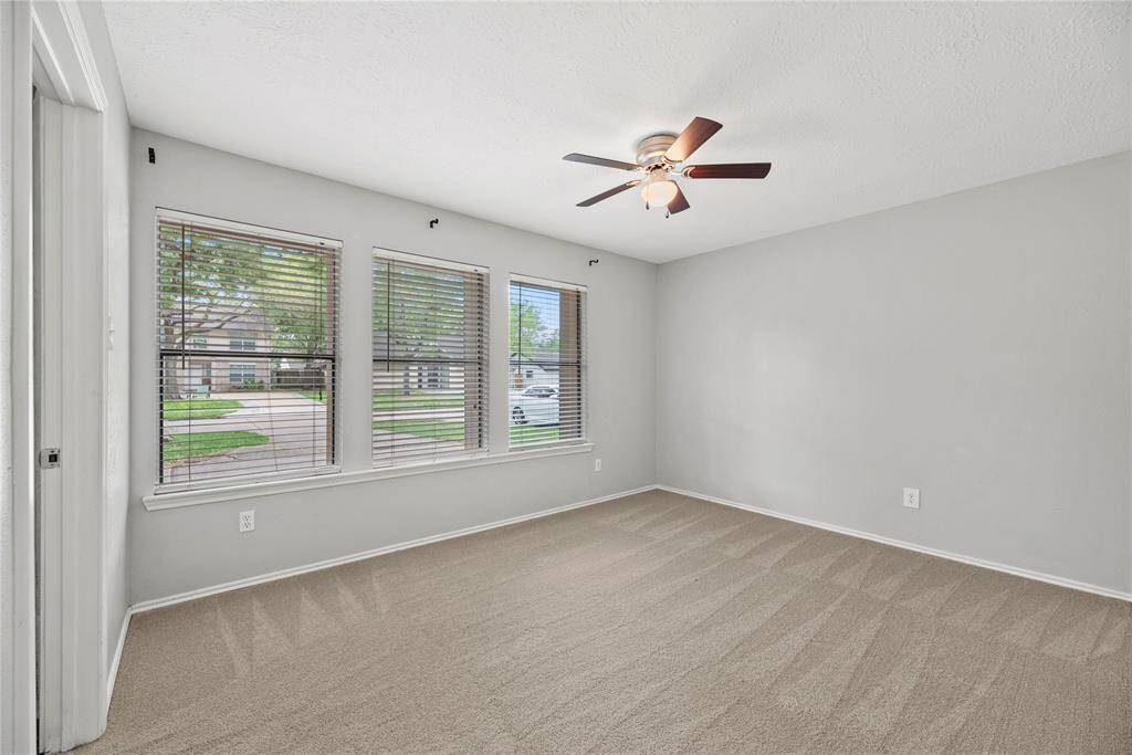 One of 3 secondary bedrooms with a fan and beautiful windows overlooking expansive front yard. Each has a walk in closet.