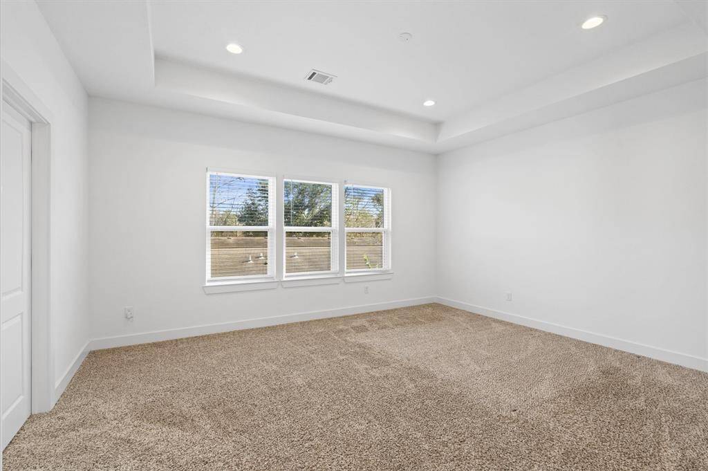 The primary suite offers lush carpeting, recessed lighting, a tiered ceiling and large windows, creating a serene retreat you'll love to unwind in each evening. On leisurely mornings, its the perfect space to relax with your favorite book or music before starting your day!
