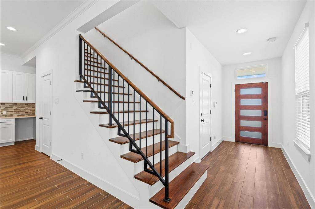 Step through the striking door and into a welcoming entryway, where you'll find access to the garage and a sleek, contemporary staircase guiding you to the second level.