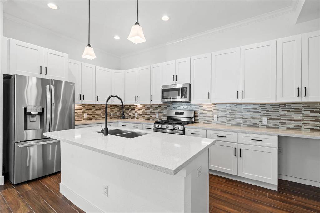 The kitchen boasts modern pendant lighting, sleek hardware, and contemporary cabinetry throughout. A mosaic backsplash adds a subtle "pop" of color, perfectly complementing the neural palette. Destined to become the heart of your intimate gatherings and complete with an under mount sink, the kitchen island is truly the centerpiece of this home. Bonus features include a generously sized pantry and a dedicated space for a beverage cooler, enhancing the functionality and charm!