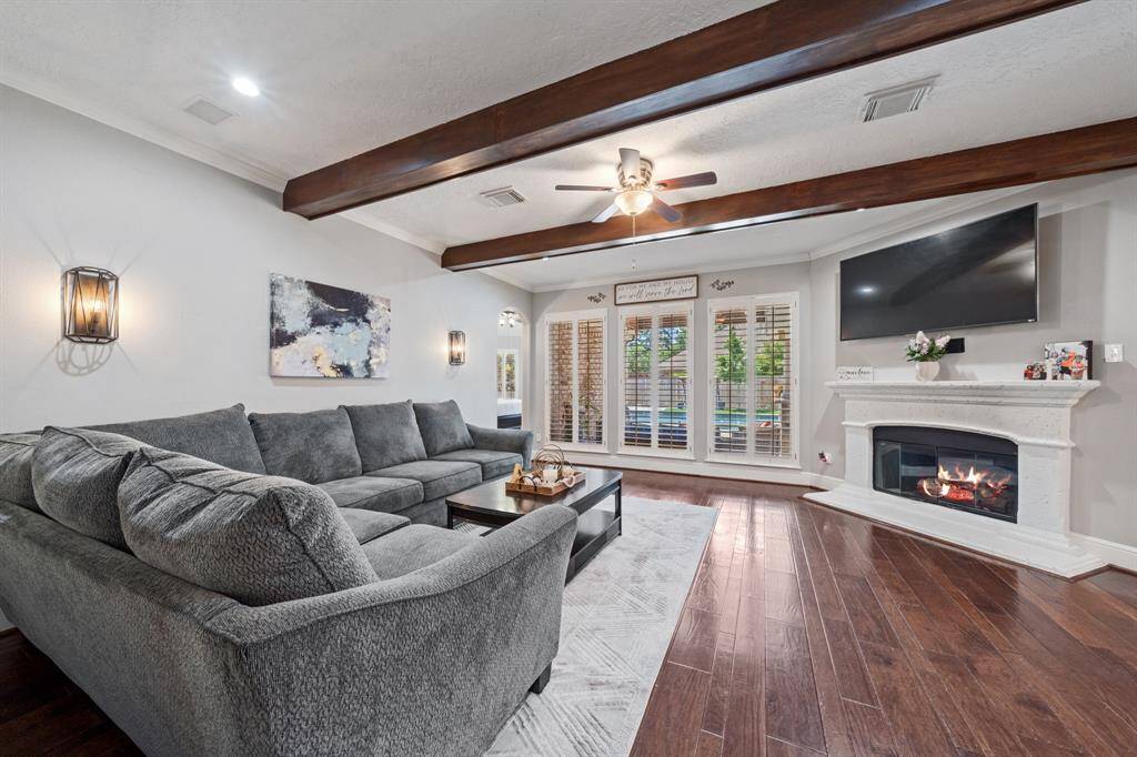 Spacious family room with gas log fireplace and wood beams.