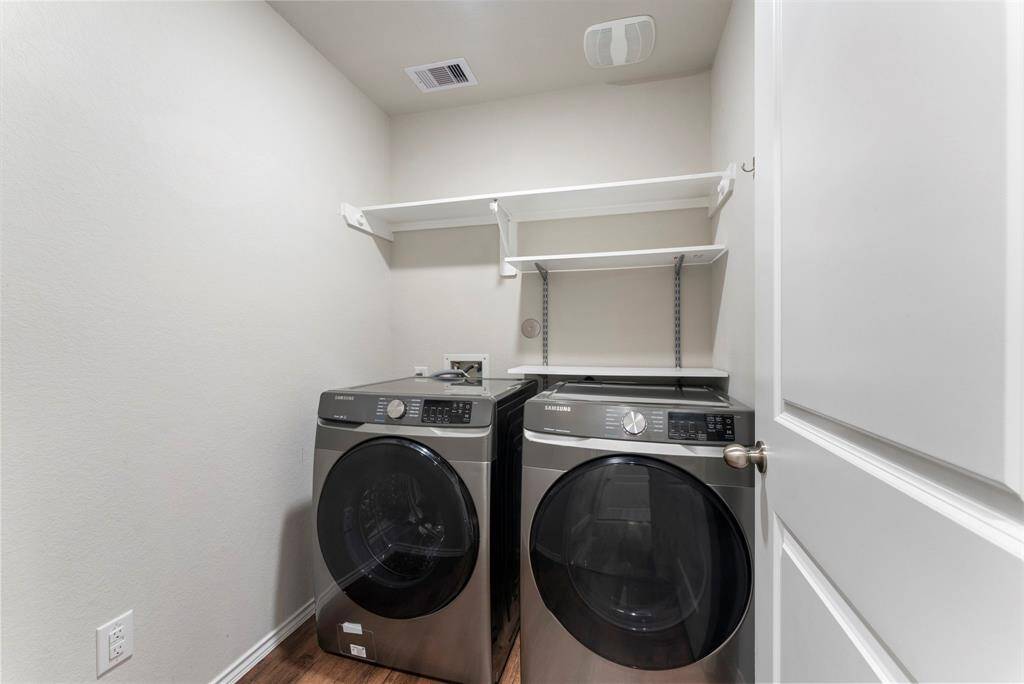 Laundry room with modern washer and dryer, and shelving for storage