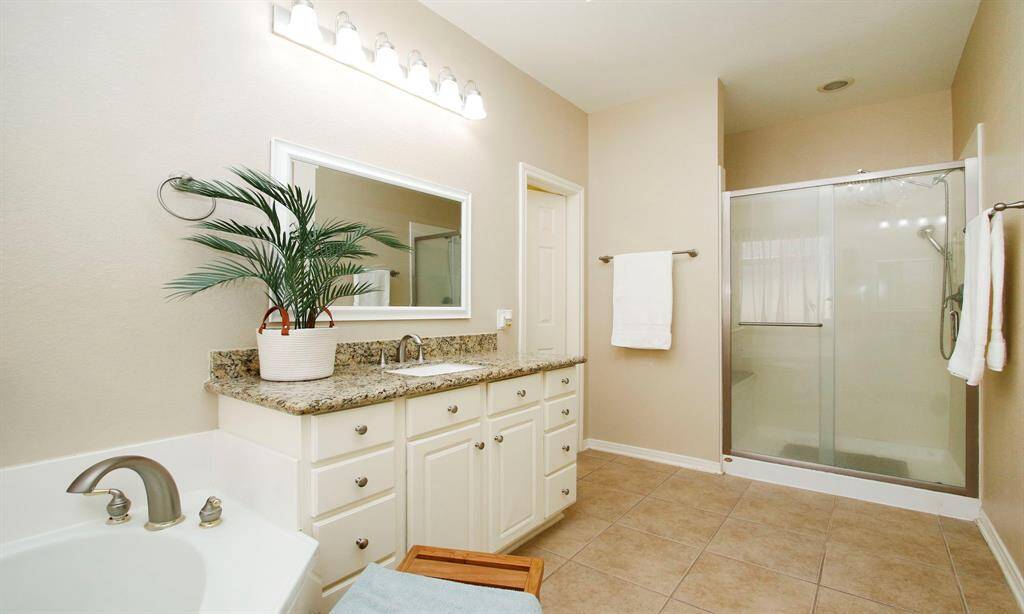 Primary bath has separate vanities and walk in shower.