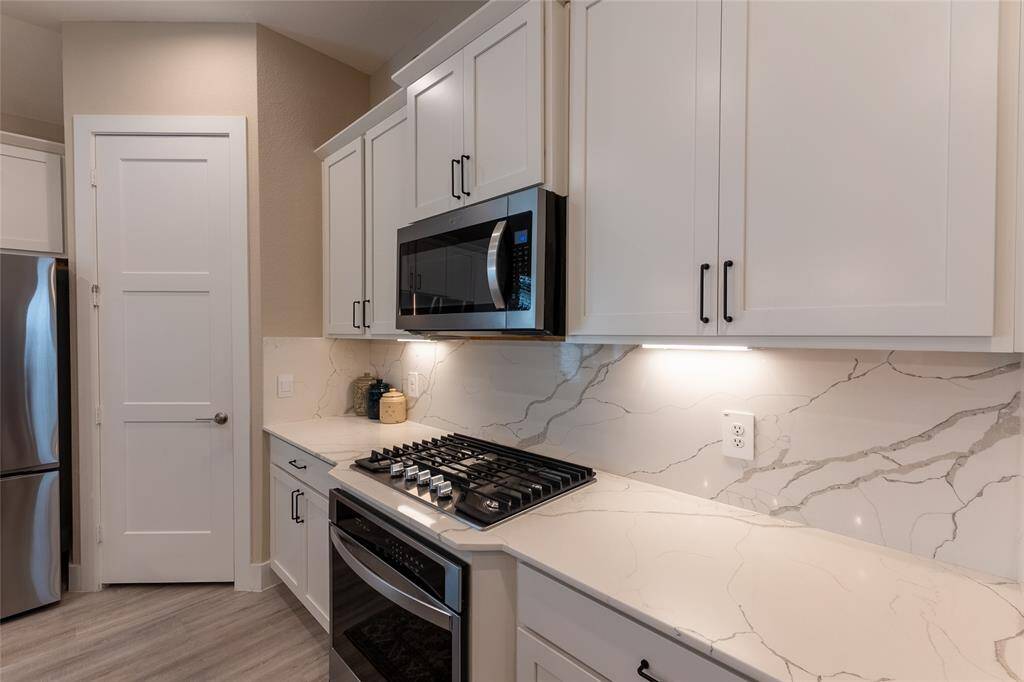 View of gorgeous quartz island and stainless farmhouse under mount sink