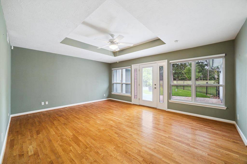 Primary bedroom with windows overlooking private patio and backyard.
