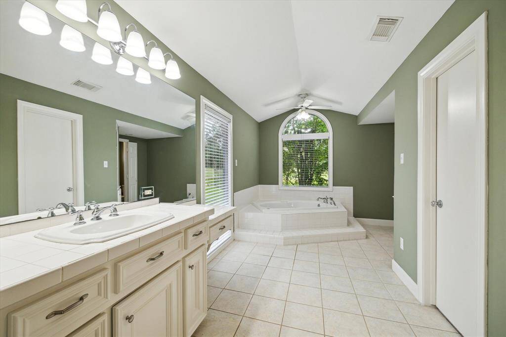 View into one section of primary ensuite  with soaker tub and walk in closet to the left.