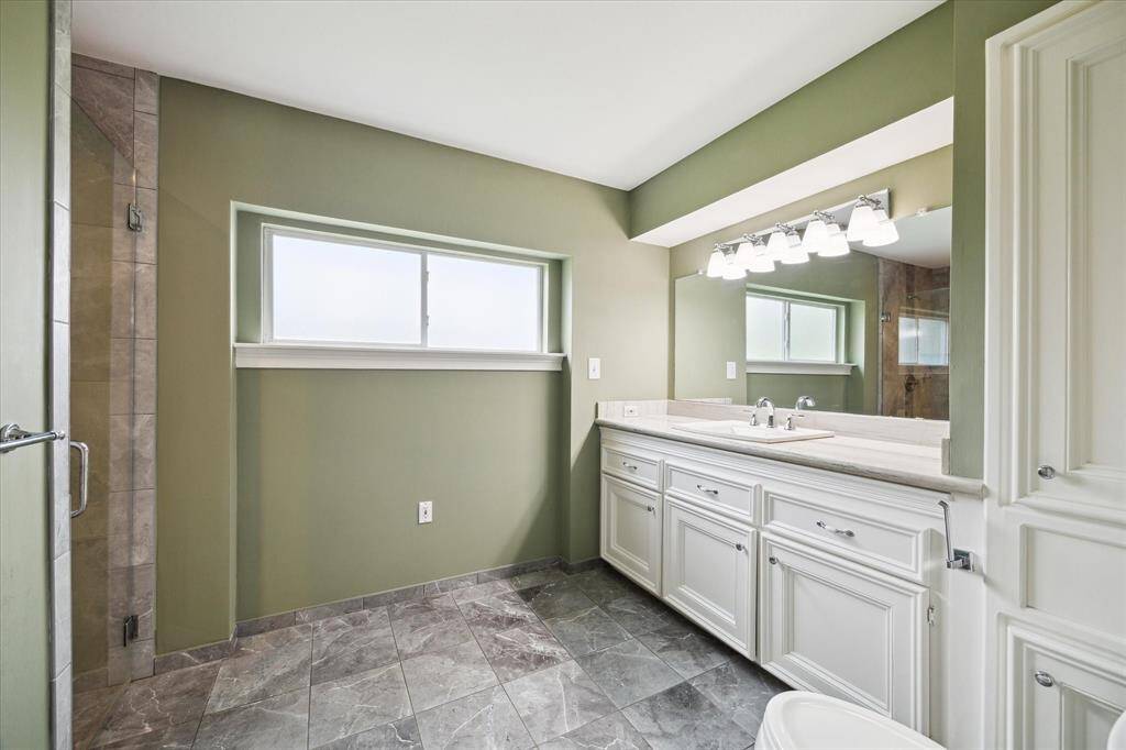 Front half of primary bathroom with separate countertop and sink. Dual opening shower to the left.