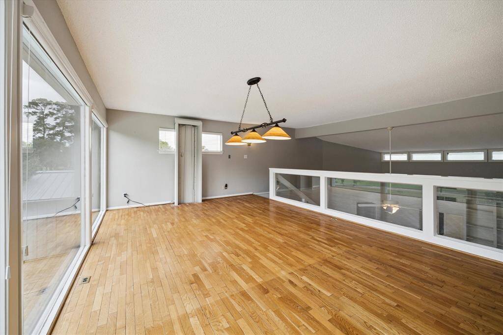 Upper loft area looking to the family room overlook and large windows overlooking pool and golf course.
