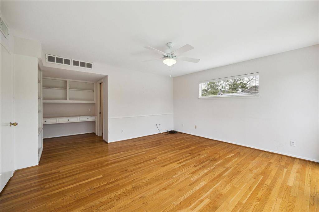 Another shot of third secondary bedroom looking toward generous built in desk and shelves. Large walk in closet to the right.