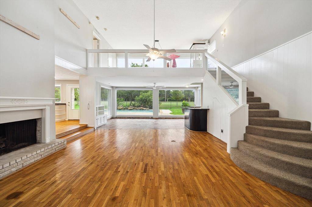 Large family room with huge windows letting in tons of natural light,  looking into the backyard, pool and golf course. Note second level loft with large windows overlooking pool and golf course.
