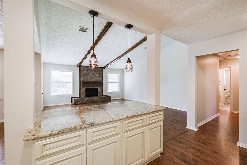 Island bar between the kitchen and the family room is perfect for entertaining. Notice the updated fixtures and granite counter tops.