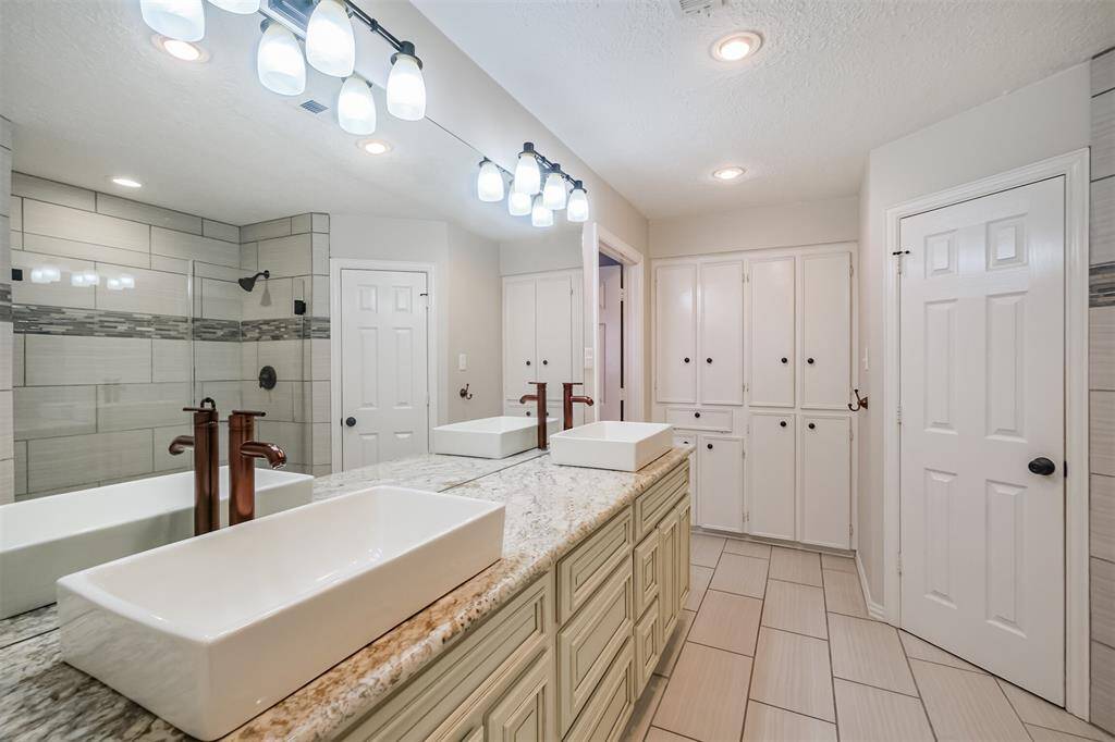 Primary bathroom offers abundance of built in storage.
