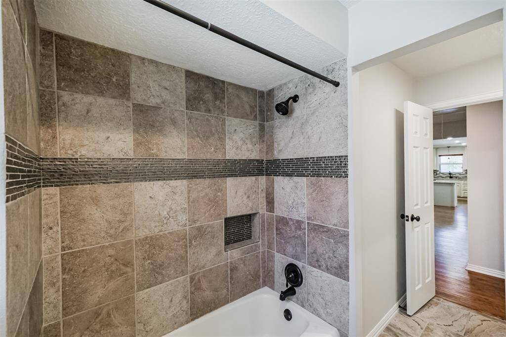 Secondary bathroom tub area features updated tiling.