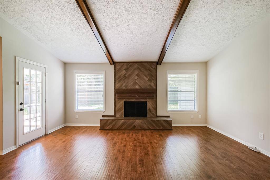 At the center of the family room you will notice the tiled fireplace along with teh vaulted ceiling and beams.
