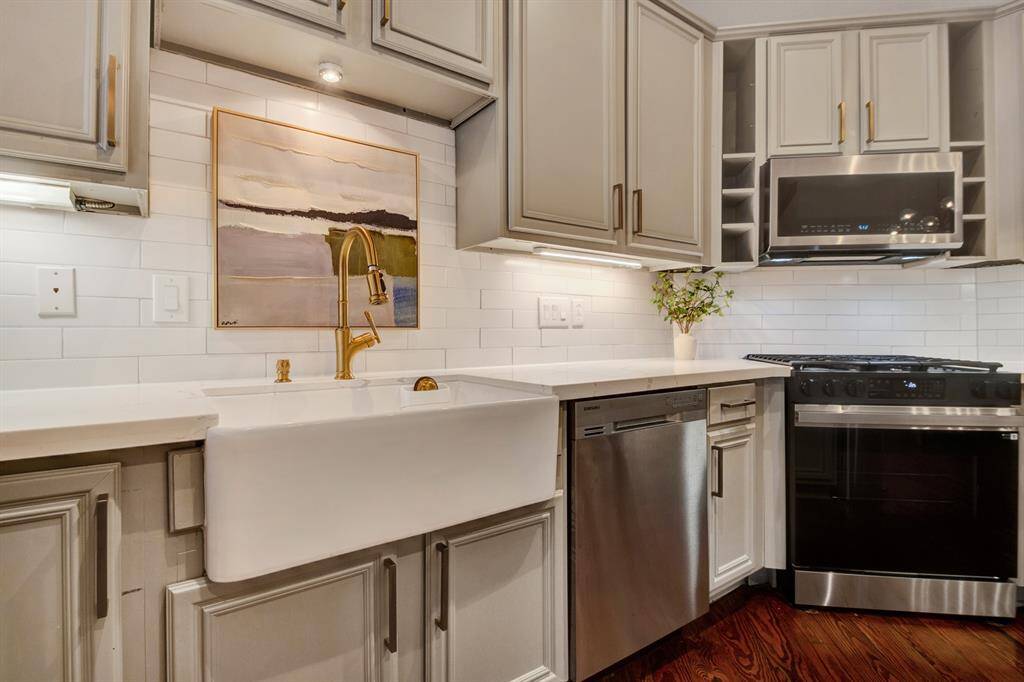 A stylish apron-front sink with brass fixtures stands out against a clean subway tile backsplash, blending form and function beautifully.