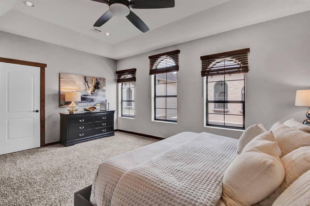Wake up to natural light pouring in through arched windows, with a tranquil view and timeless architectural charm. A tray ceiling and ceiling fan enhance the elegance of the primary suite, offering multiple layout options and exceptional comfort.