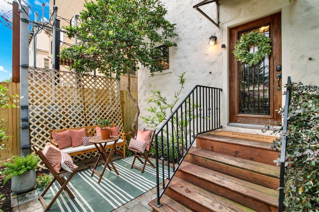 Tucked just off the front entrance, this inviting patio space features seating, greenery, and privacy lattice — ideal for entertaining or relaxing al fresco.