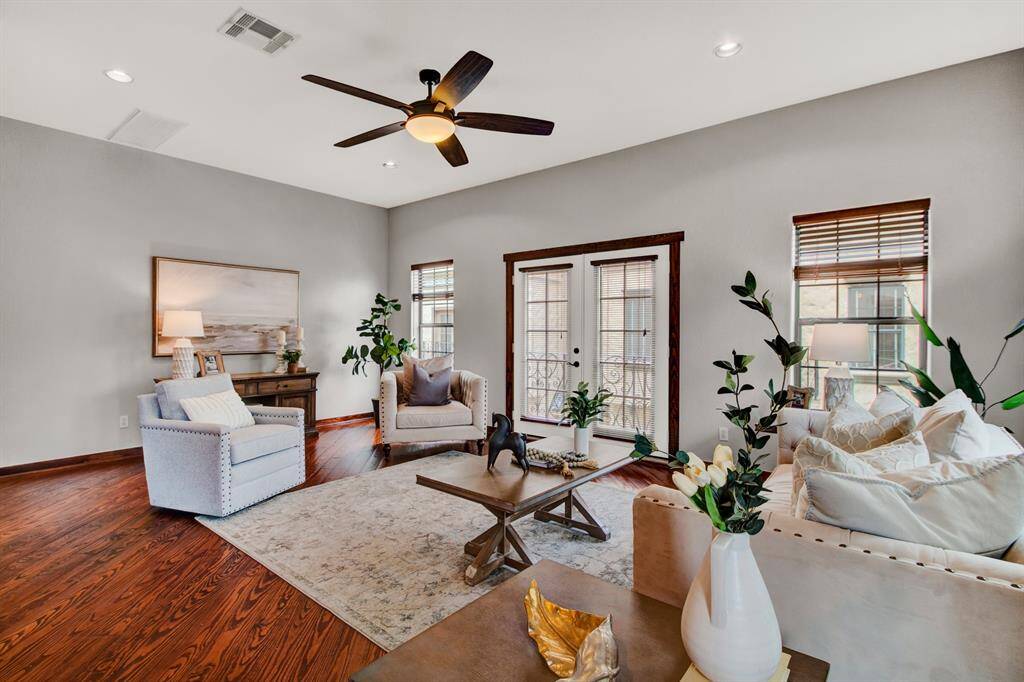 The light-filled living room is anchored by beautiful hardwood floors and opens to a Juliet balcony through French doors, perfect for relaxing or entertaining.