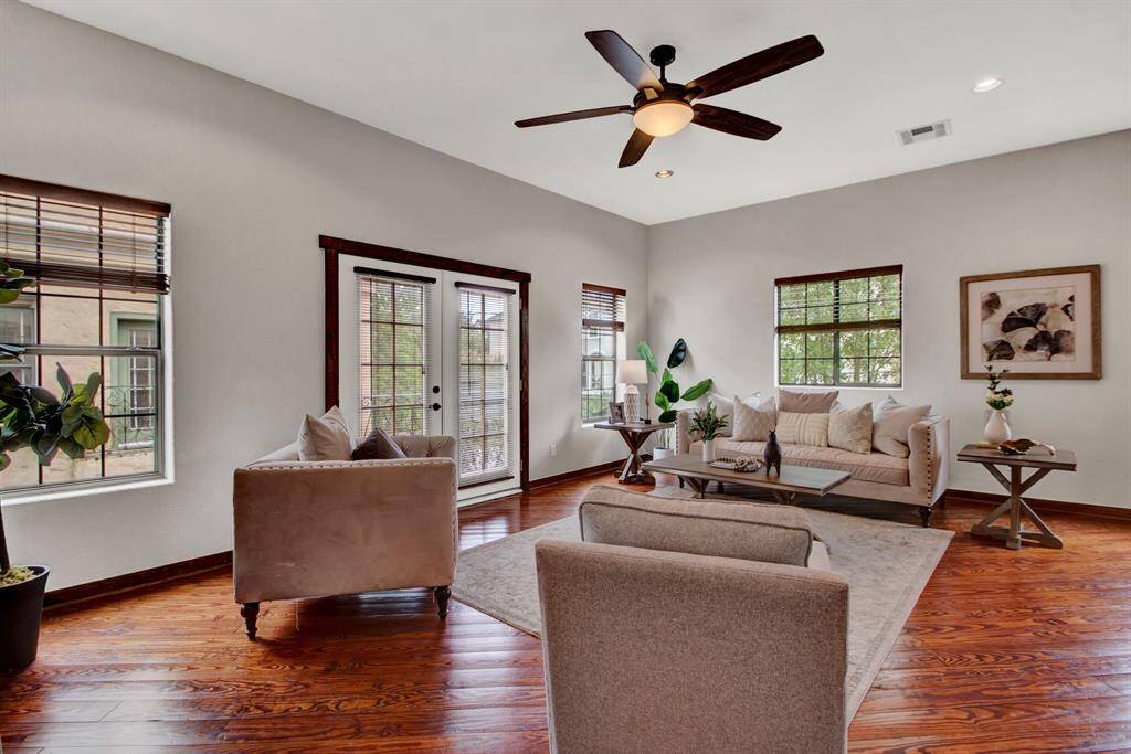 This spacious living area offers multiple seating zones and abundant natural light from every angle, creating a bright and airy atmosphere.