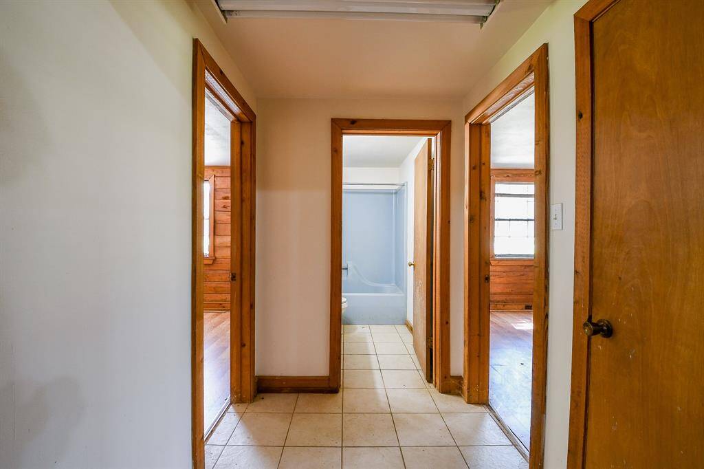 This small hallway off the main living area shows the layout of the two secondary bedrooms downstairs and the full bath.