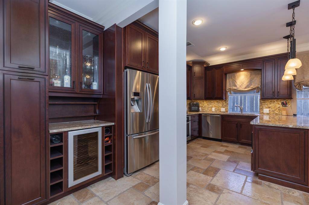 Butler's pantry includes slide out pantry storage and a wine fridge