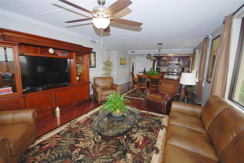 Living room with engineered hard wood floors is open all the way to the kitchen.