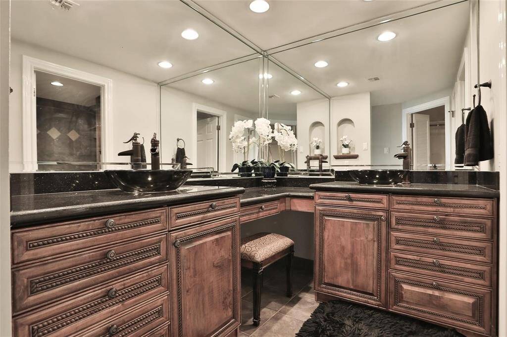 The primary bathroom has stunning cabinetry and granite counter.