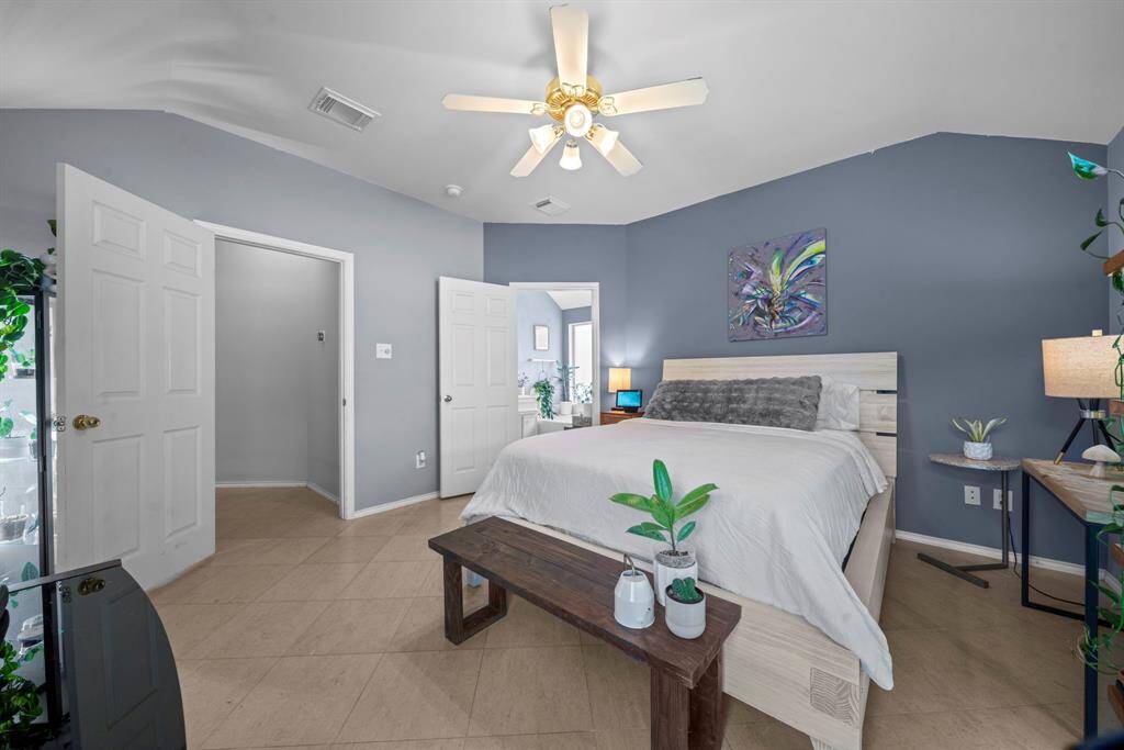 Primary bedroom with soothing blue-gray walls, en-suite access, and abundant natural light.