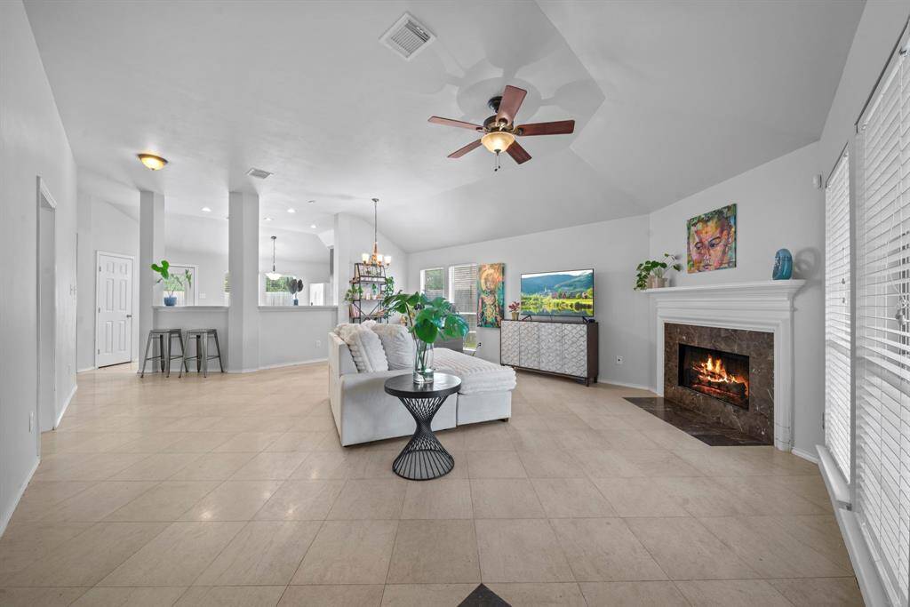 Bright and open living area, cozy fireplace, and seamless flow to the kitchen and dining spaces.