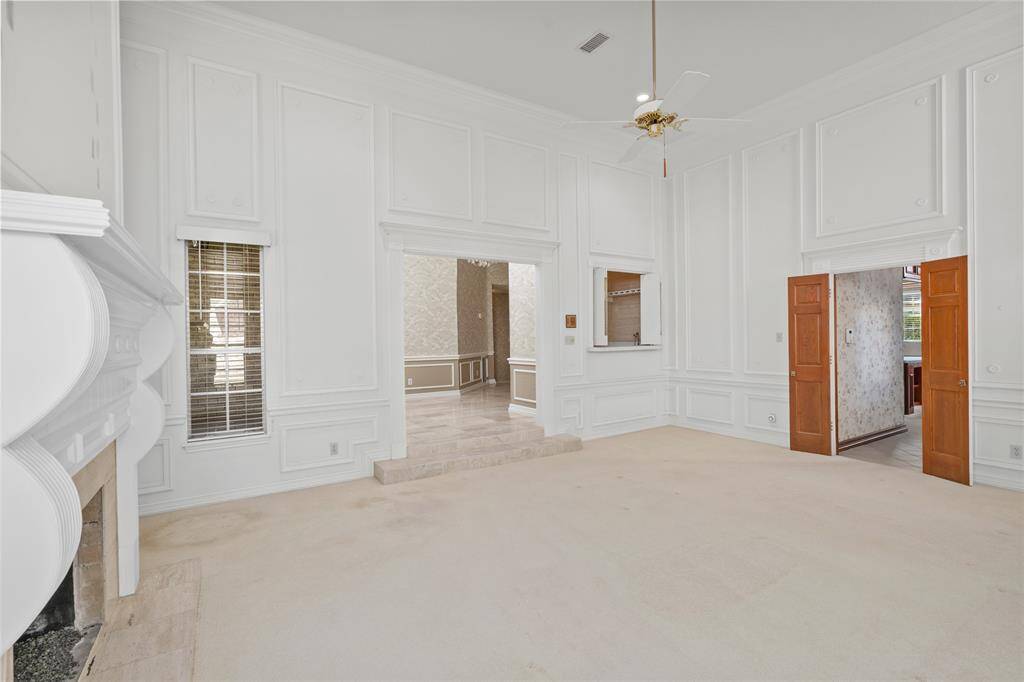 Another view of your new living room featuring the fireplace mantle and pass through window from the wet bar.