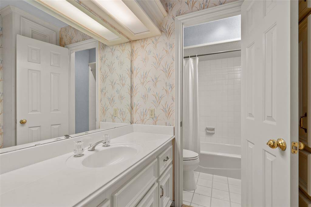 Another en-suite bath with a classic design. The large vanity provides ample counter space, and storage. The shower-tub combo with white tile surround add character.