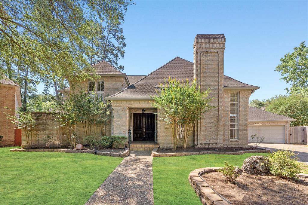 Your new home has a wide pathway leading to the front door. The entrance features a covered porch, and there is a prominent chimney adding character to the facade. The driveway leads to a spacious garage, enhancing curb appeal.