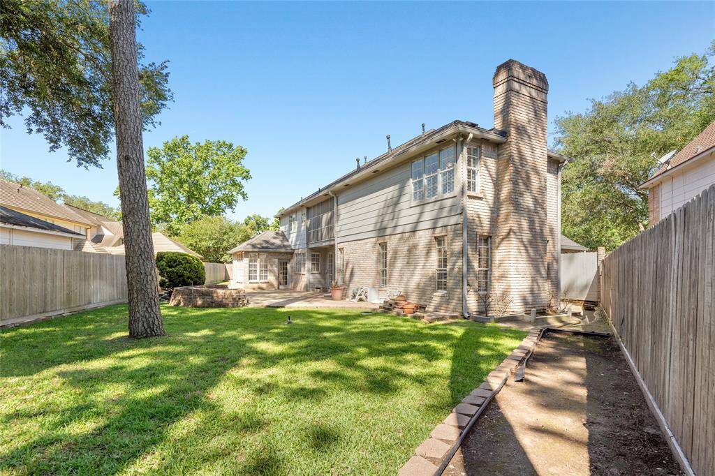This view of the back of your house features the chimney, patio and side garden awaiting your personal touch.