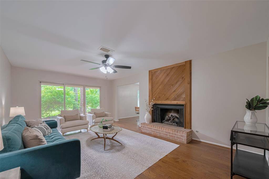 This Living Room offers large windows on each side of the sliding door and a lovely Cedar accent wall fireplace.