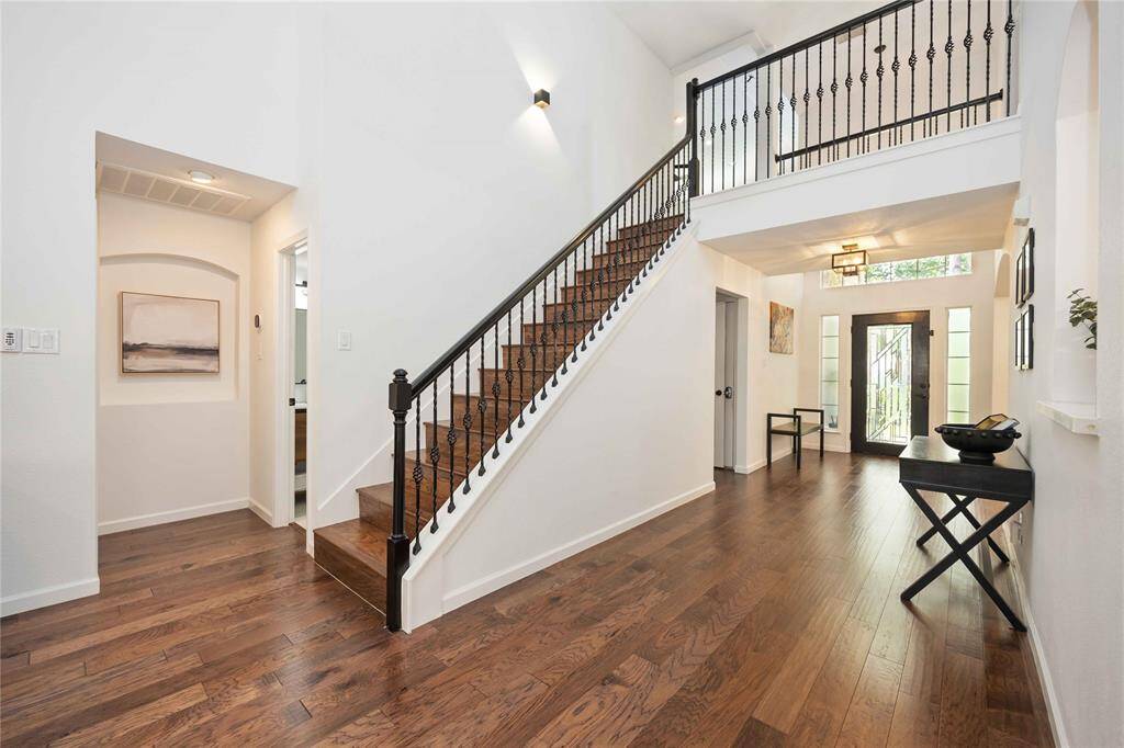 Soaring ceilings and wrought iron staircase create a modern, open feel.