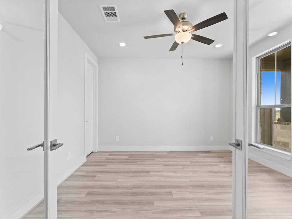Double Doors Open to the Home/Office Study with Large Window, LVP Flooring, and Storage Closet.