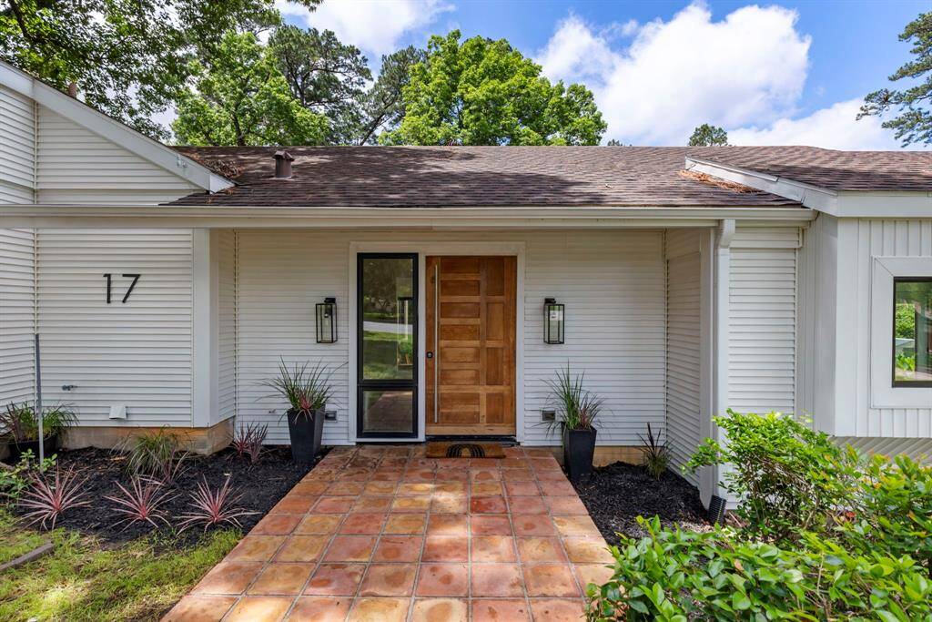 The modern front door is beautifully complemented by the warm, earthy tones of the Saltillo tile.
