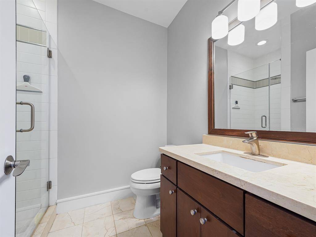 Indulge in the comfort of your private ensuite bathroom, featuring a sleek vanity with ample storage and a beautifully tiled shower for a spa-like experience.